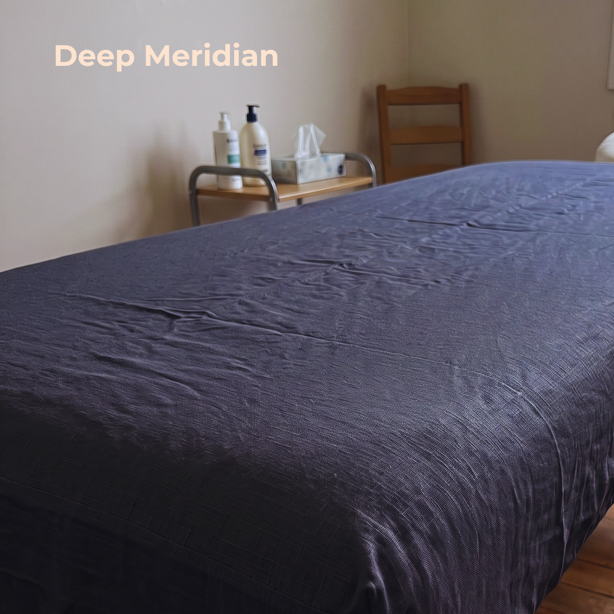 A dark meridian gray-blue textured sheet or duvet spread across a bed in a softly lit room, with the text 'Deep Meridian' in the upper left corner.