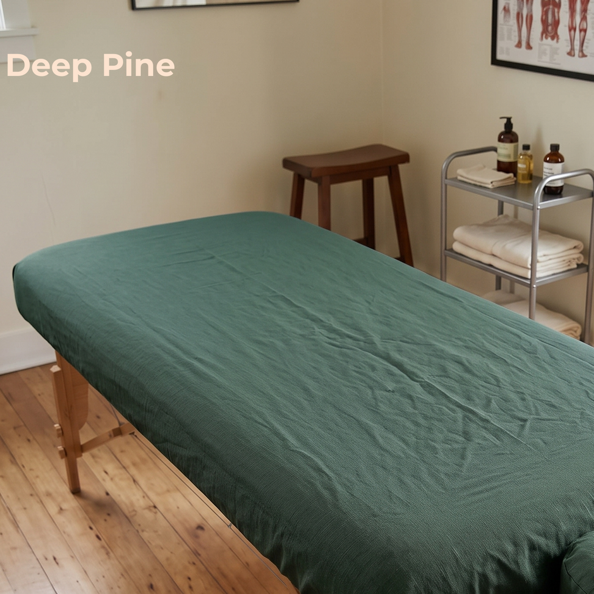 A dark green massage table cover or sheet spread across a treatment table in a spa-like room with a wooden stool, metal cart, and wood floor. The text 'Deep Pine' appears in the upper left corner.