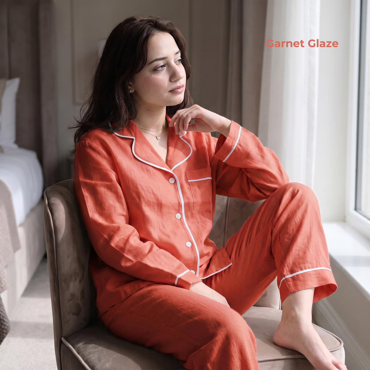 Woman in red pajamas sitting on a chair by a window, with 'Garnet Glaze' branding.