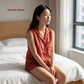 Woman sitting on a bed wearing a red sleeveless top, with 'Garnet Glaze' text in the corner.