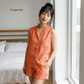 Woman wearing an orange pajama set in a bedroom with 'Tangerine' text.