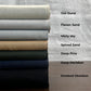Six folded fabric swatches are stacked vertically on a white sheet, with text labels pointing to each color: Oat Dune, Flaxen Sand, Misty sky, Spiced Sand, Deep Pine, Deep Meridian, and Smoked Obsidian.